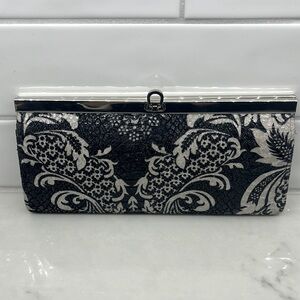 Sleek black patterned clutch, with silver trim, 6.5” x 3”.